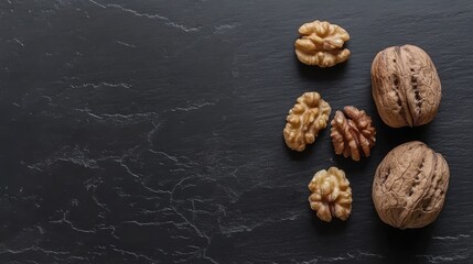 Poster - Walnuts in shells and shelled on dark stone background with Copy Space for text