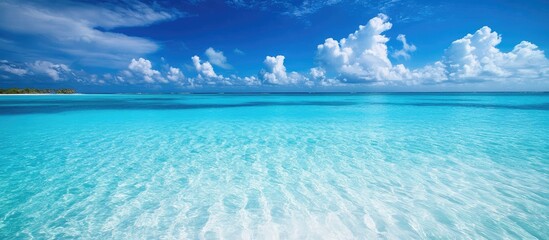 Poster - Crystal clear turquoise ocean water with gentle waves and dramatic clouds under a bright blue sky Copy Space