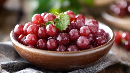 Poster - Fresh red grapes in a brown bowl on a rustic wooden table with green leaves in the background and Copy Space for text placement