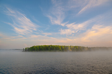 Wall Mural - a beautiful autumn morning landscape with a misty riverbank and a blue sky with pink clouds.