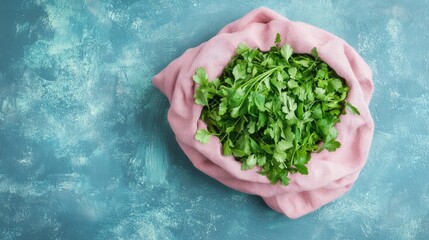 Poster - Fresh cilantro leaves in a soft pink cloth bag on a textured blue background with copy space for text.