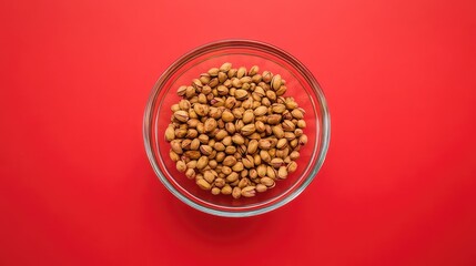 Poster - Bowl of roasted pumpkin seeds on red background with copy space for text.