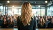 © Maximages  - Image of a woman standing at the podium in front of a large audience, delivering a speech in a well-lit conference room. Captures the essence of public speaking.