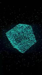 Aufkleber - Abstract 3D glowing turquoise cube composed of tiny particles, floating in space against a dark black background, evoking a futuristic and digital aesthetic. Vertical video animation