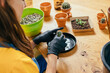 © Iryna - Home planting on the kitchen. Free time for little house gardening concept. View from above of unrecognizable woman replanting cactus at wooden table in home.
