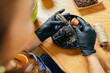 © Iryna - Home planting on the kitchen. Free time for little house gardening concept. View from above of unrecognizable woman replanting cactus at wooden table in home.