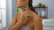 © Krakenimages.com - Young woman using jade roller in spa salon for facial massage in a relaxing indoor wellness setting