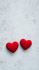 Poster - Two red hearts lying on a white textured background create a romantic atmosphere, perfect for valentine's day, women's day, or any occasion celebrating love and affection