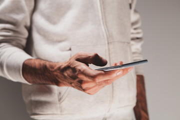 Wall Mural - cropped shot of male hands typing on smartphone.