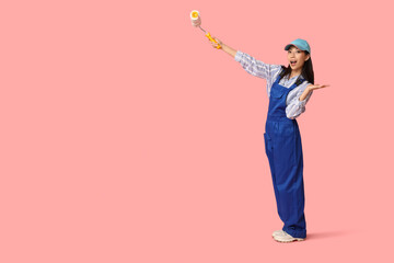 Wall Mural - female asian shocked painter with roller on pink background