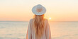 © A2Z AI  - Woman in a sun hat watching the sunset over the ocean. Serene and peaceful moment captured at golden hour.