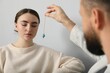© New Africa - Psychologist using pendulum while working with patient during hypnosis session indoors