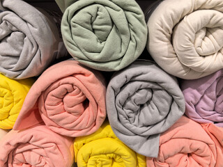 Wall Mural - Colorful rolled blankets stacked neatly in a cozy home decor shop display