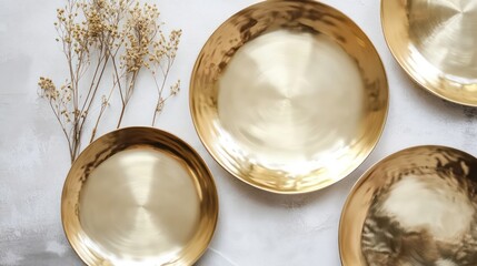 Poster - Gold metallic plates and dried flowers on white background.