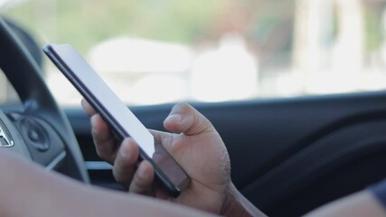 Poster - Closeup hand of a man holding a smartphone in a car. A person is using a phone by pressing his finger on the screen to enter the password code to unlock it. People use a mobile phone in everyday life.