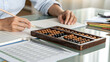 © Kanika Graphic - Focused Student Using Abacus for Math Calculations and Study Work