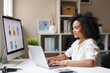 © SimpleDesignStudio - Professional Woman Working at Desk with Laptop While Analyzing Digital Design Projects on Screen in Modern Workspace