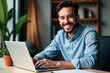 © SimpleDesignStudio - Happy Young Man Working on Laptop in Modern Office Environment Surrounded by Indoor Plants and Comfortable Decor