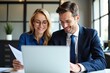 © SimpleDesignStudio - Smiling Business Couple Collaborating on a Laptop in an Office Workspace, Showcasing Professional Teamwork and Digital Interaction