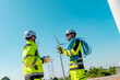 © Hip.hub - Technicians inspect wind turbine at renewable energy site during bright sunny day
