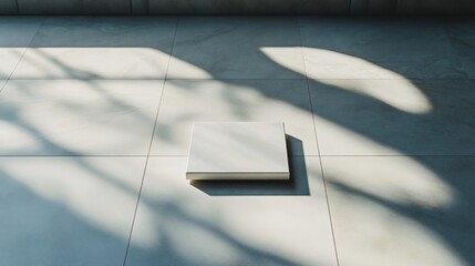 Wall Mural - White square box on light tile floor with sunlit shadows.