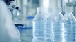 © NAIMAH - Water bottles on a lab counter, next to a microscope.