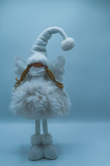 Funny gnome made of white fur, on a blue background.