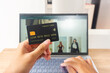 © Tito Rollis - Pov first person holding black mockup credit card while typing for online shop on laptop in home