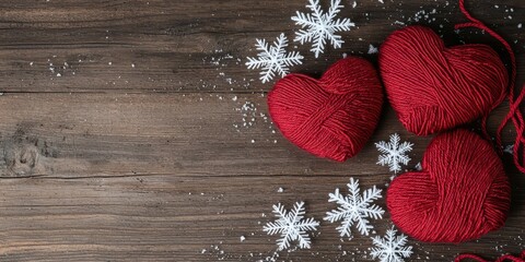 Wall Mural - Three handmade heart-shaped yarns on a wooden table with snowflakes. Winter romance decoration