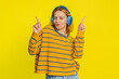 © Andrii Iemelianenko - Happy joyful Caucasian woman in blouse listening music on headphones and dancing disco fooling around having fun expressive gesticulating hands. Young adult girl isolated on yellow background indoors