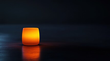 Wall Mural - Glowing Orange Candle in Dark Background for Relaxing Atmosphere