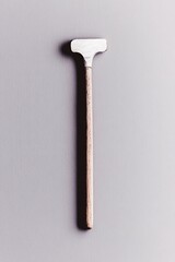 Wall Mural - Small wooden hand tool with a white head, isolated on gray background.