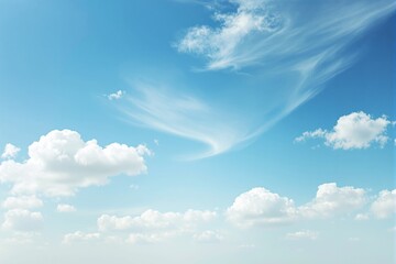 Poster - Fluffy white clouds drifting in a bright blue sky with soft, wispy clouds.