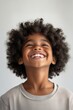 © Bojan - Bright smile of an African American boy with curly hair showing joy indoors during daytime