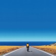 © Jetsomboon - Cyclist Riding Along Coastal Roadway