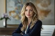 © Vibu design  gallery - A blonde woman in a navy blue blazer sits confidently, exuding professionalism and elegance.
