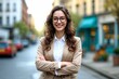 © Robbie Smith 1  - Young happy pretty smiling professional business woman, happy confident positive female entrepreneur standing outdoor on street arms crossed, looking at camera