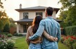 © miss irine - Happy couple stands in front of new house. They look at new home admiringly. Beautiful garden surrounds new house. Love, happiness in new property. Lifestyle image of new home. They embrace with love.