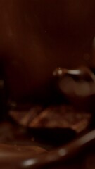 Poster - Super Slow Motion of Falling Group of Chocolate Chunks. Splashing into Melted Chocolate. Filmed on High Speed Cinema Camera, 1000fps. Vertical Aspect Ratio.