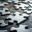© jambulart - Silver Puzzle Pieces Scattered on Dark Surface