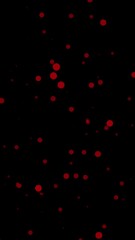 Poster - Bright red particles spread across a black background, Vertical video animation 