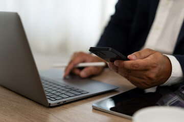 Poster - a man is using a laptop and a cell phone at the same time
