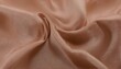 © piyawat - CloseUp of Light Peach Silky Fabric with Subtle Sheen, Folds, and Creases  TopDown Perspective Showing Movement and Depth.
