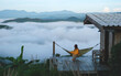 © Farknot Architect - Portrait of a woman sitting on hammock and looking at a mountain view and sea of fog