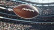 © Business Pics - An American football flies through the air with dynamic motion trails behind it, soaring over a crowded stadium.