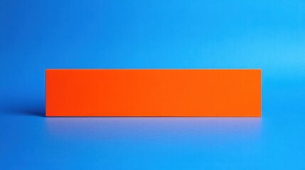 Wall Mural - A vibrant orange rectangular block set against a bright blue background, ideal for creative projects or design concepts.