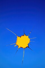 Poster - Vibrant yellow paint splatter against a clear blue sky, creating a striking visual contrast and artistic effect.