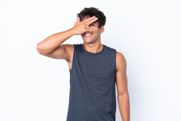 Young sport caucasian man isolated on white background covering eyes by hands and smiling