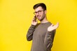 © luismolinero - Young caucasian man isolated on yellow background keeping a conversation with the mobile phone with someone