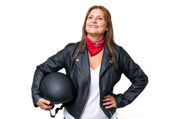 Wall Mural - Middle-aged caucasian woman with a motorcycle helmet over isolated background posing with arms at hip and smiling